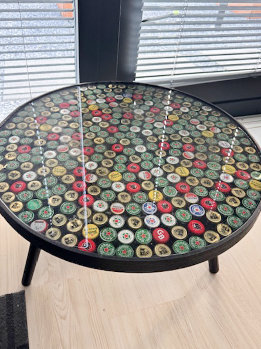 een salon tafel waar er bierdopjes in de epoxy giethars zijn verwerkt.